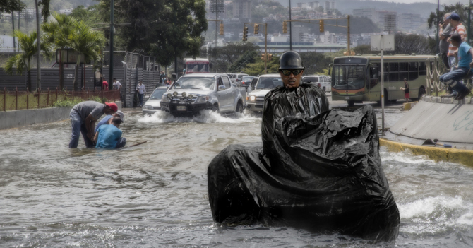 Lluvias hacen que motorizado se meta en bolsa negra para llegar a su casa