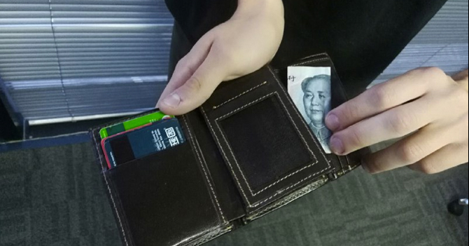 Joven mete yuan de la suerte en la cartera luego de tener que usar su dólar para comprar cigarro detallado