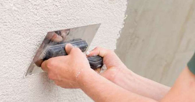 Albañil frisa pared con leche del CLAP