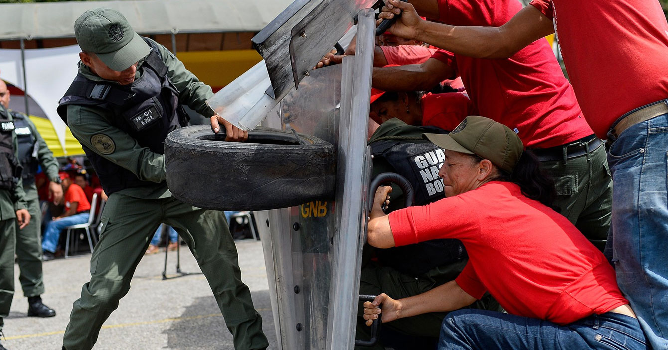 Milicianos entrenan en caso de que fuerza militar extranjera ataque con cauchos viejos